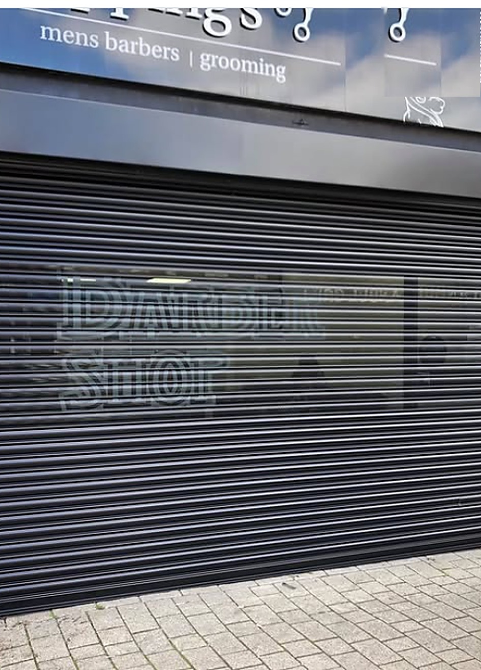 Black security roller shutter on a barber shopfront — Wilks install